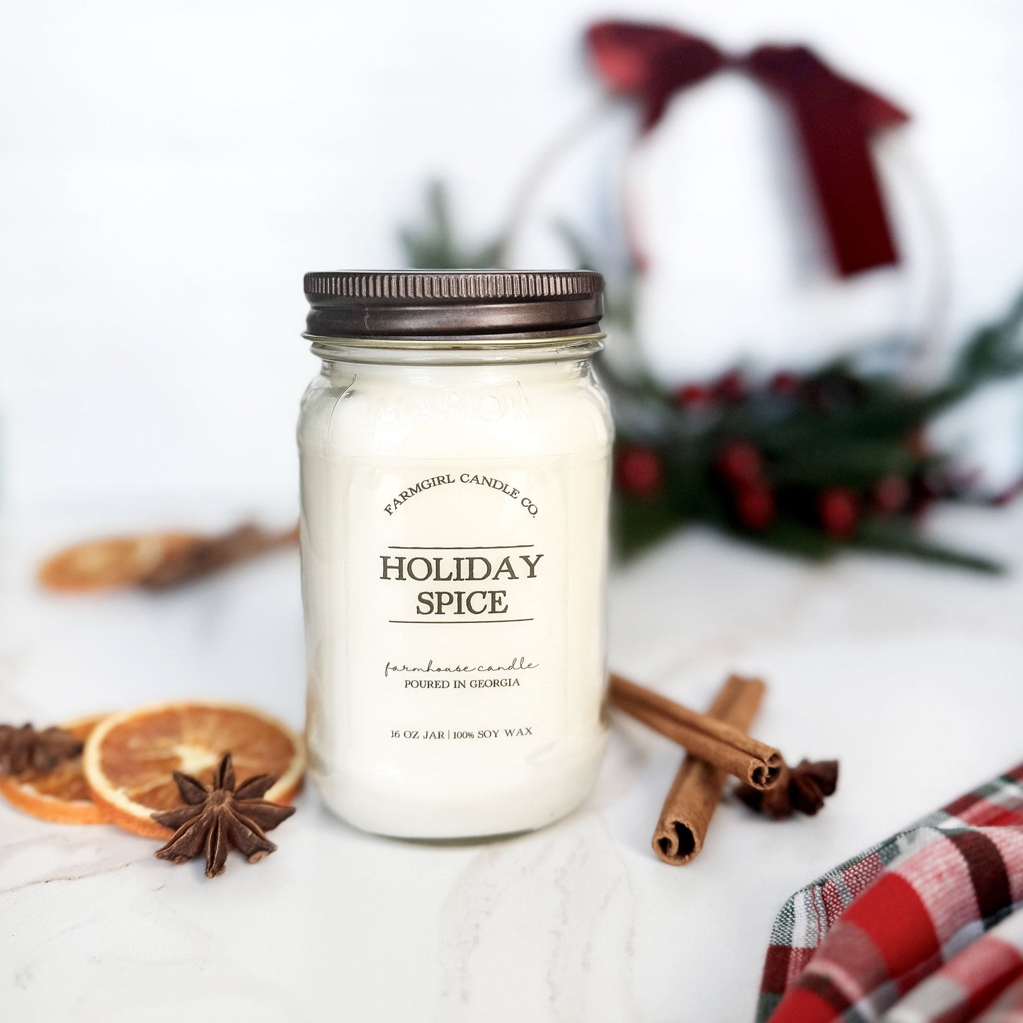 Mason Jar of 'Holiday Spice' candle with cinnamon sticks and dried oranges